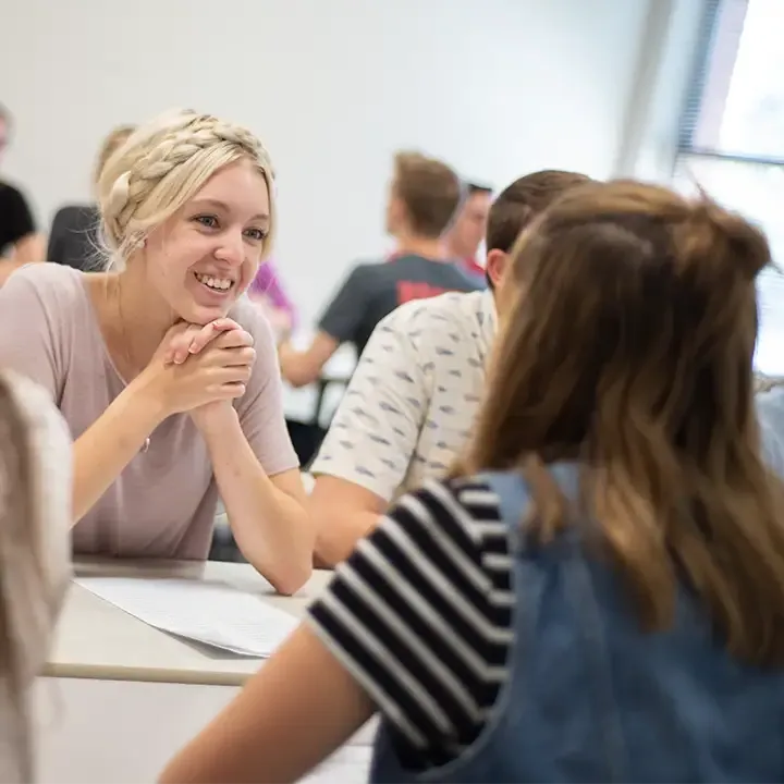 Woman smiling in room full of people