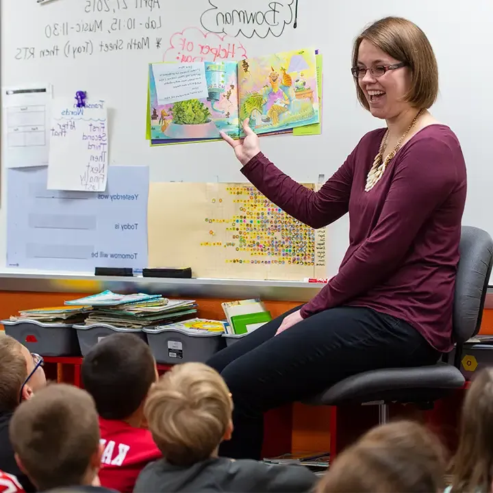 Woman teaching primary-aged children.