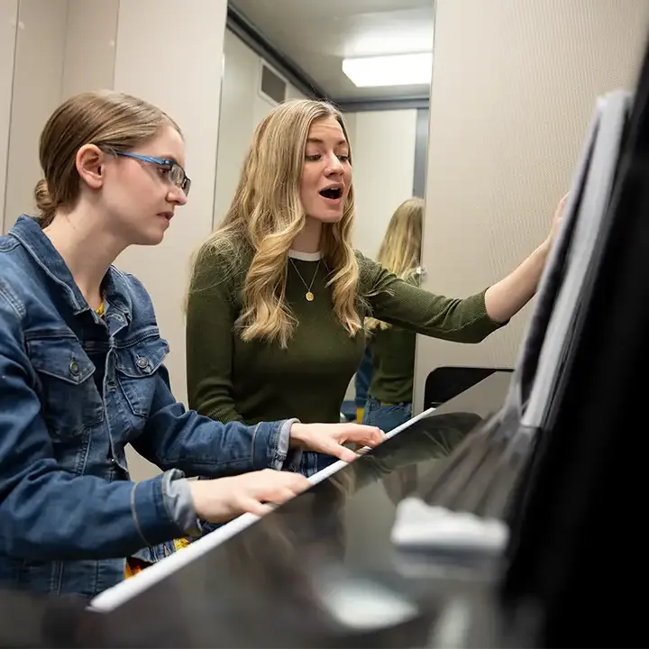 Two women sitting at a piano