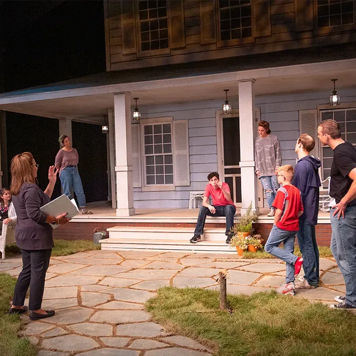 Professor Stratton leading a theatre rehearsal onstage.